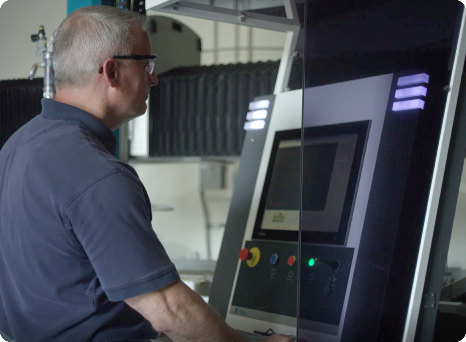 operator using a flow roll around control unit in front of a waterjet